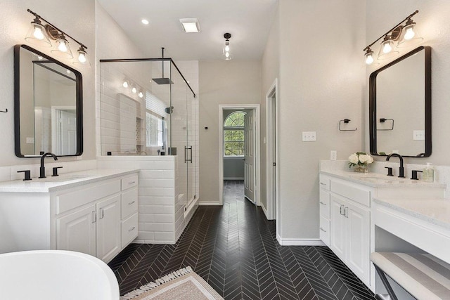 full bathroom featuring two vanities, a sink, and a stall shower