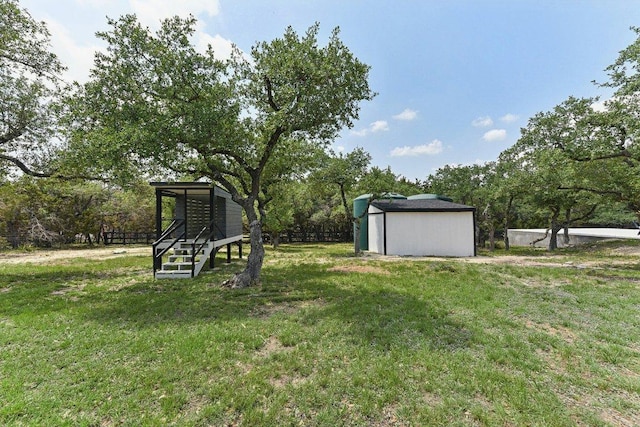 view of yard with an outdoor structure, a shed, and fence