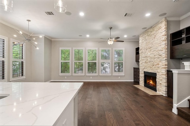 unfurnished living room with a healthy amount of sunlight, crown molding, and visible vents
