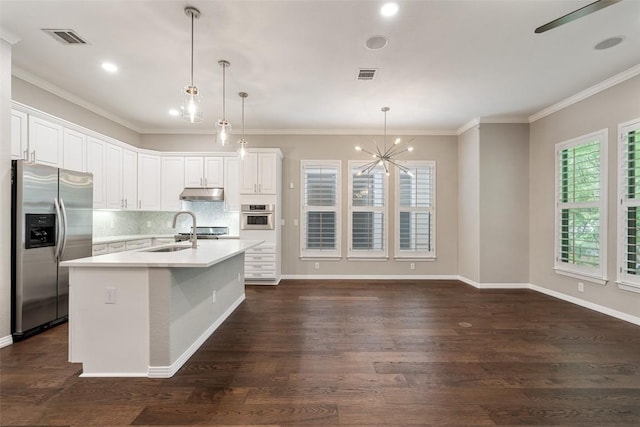 kitchen featuring visible vents, appliances with stainless steel finishes, a sink, light countertops, and a notable chandelier