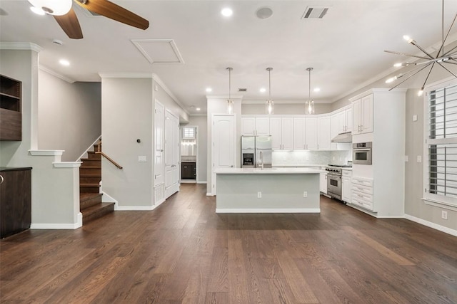 kitchen featuring visible vents, a kitchen island with sink, light countertops, white cabinets, and appliances with stainless steel finishes