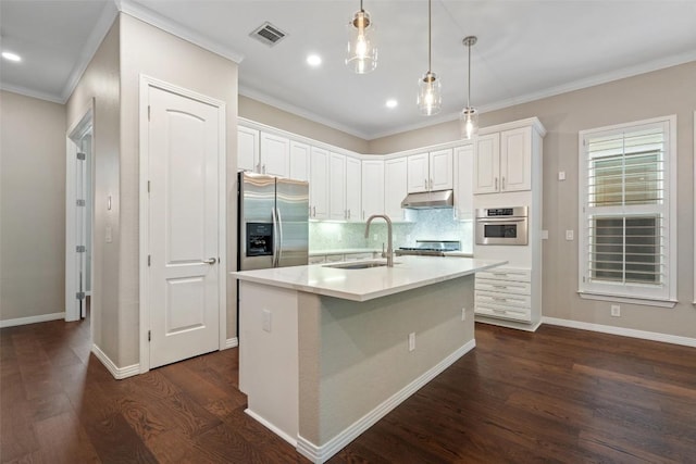 kitchen featuring visible vents, a sink, under cabinet range hood, stainless steel appliances, and dark wood-type flooring