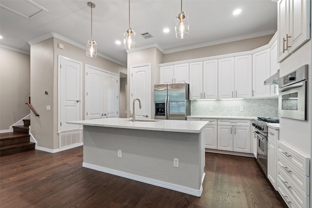 kitchen featuring appliances with stainless steel finishes, a sink, white cabinetry, visible vents, and ornamental molding