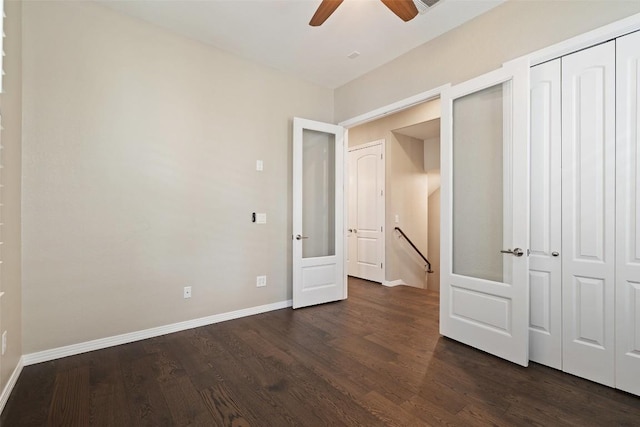 unfurnished bedroom featuring baseboards, ceiling fan, a closet, and dark wood finished floors