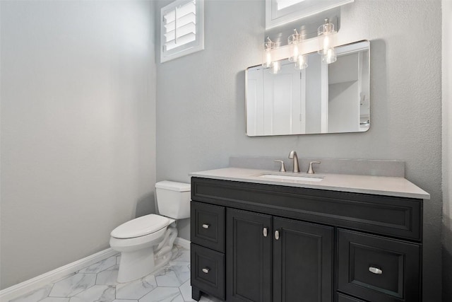 bathroom featuring vanity, baseboards, toilet, and marble finish floor