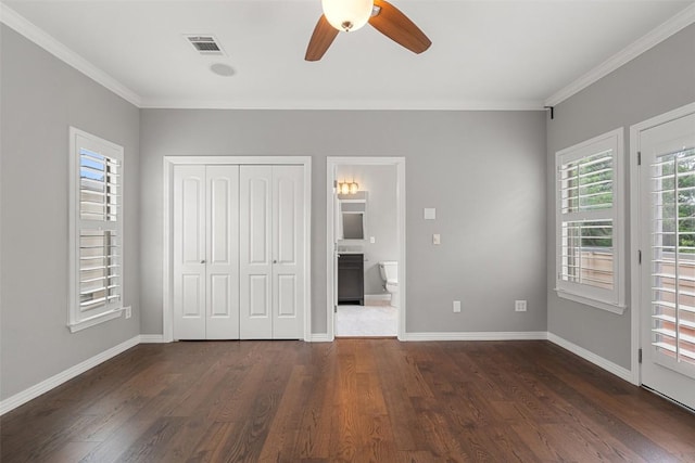 unfurnished bedroom featuring visible vents, ornamental molding, dark wood-style flooring, and baseboards