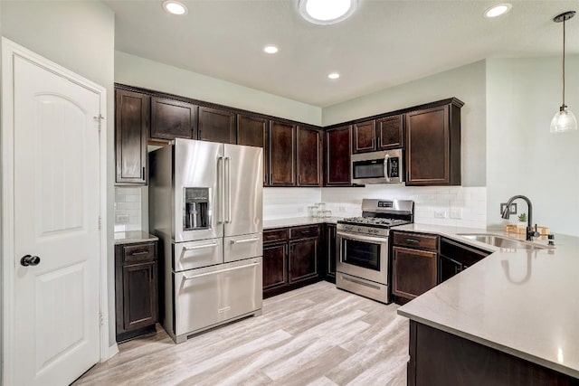 kitchen with backsplash, dark brown cabinets, a sink, light wood-style floors, and stainless steel appliances