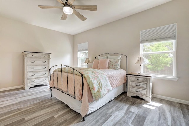bedroom with baseboards, ceiling fan, and wood finished floors