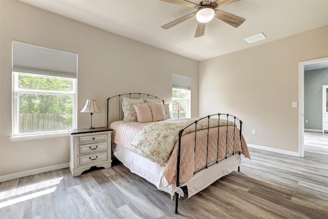 bedroom featuring visible vents, multiple windows, and light wood finished floors