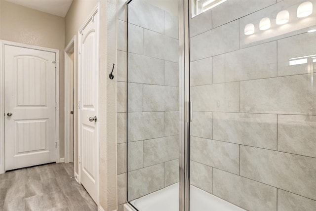 full bath with a shower stall and wood finished floors
