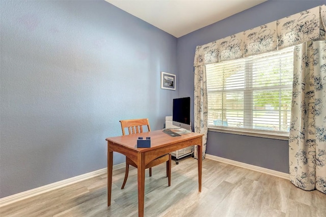office space featuring light wood-type flooring and baseboards