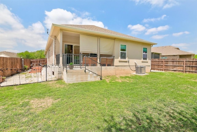 back of property with a fenced backyard, stucco siding, a yard, and a patio area