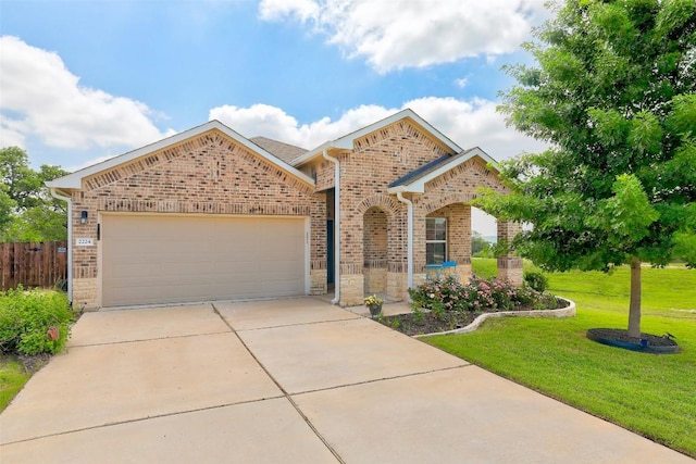 view of front facade featuring fence, a front yard, brick siding, concrete driveway, and an attached garage