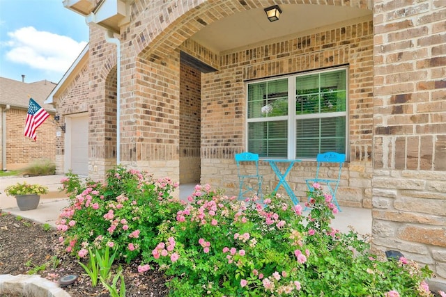 property entrance with brick siding and a porch