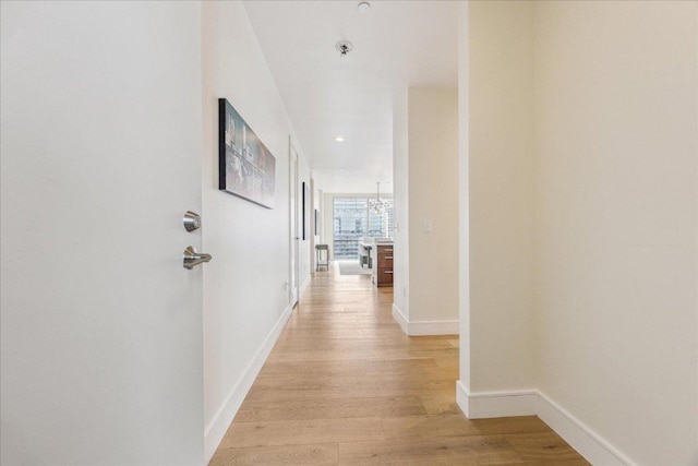 corridor with recessed lighting, baseboards, and light wood-type flooring