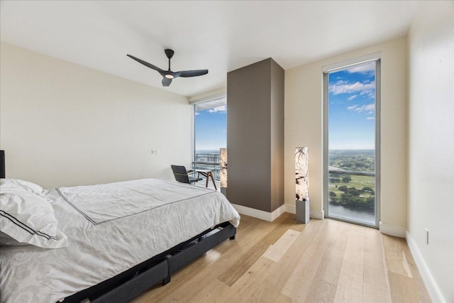 bedroom featuring a ceiling fan, baseboards, access to exterior, and light wood-style flooring