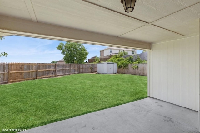 view of yard with a fenced backyard, a patio, an outbuilding, and a storage shed