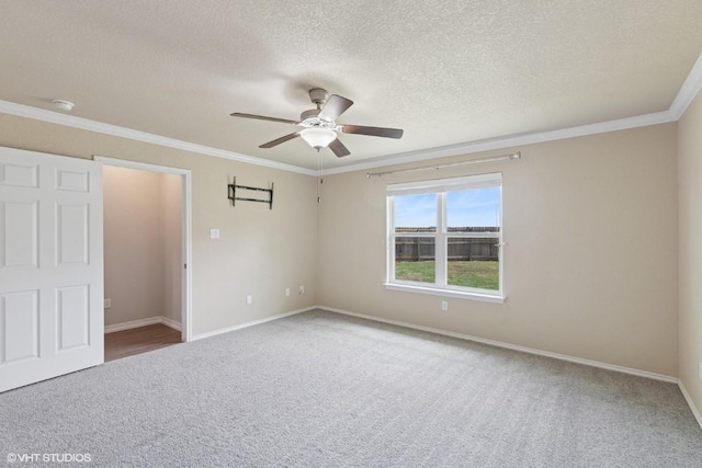 unfurnished bedroom with carpet flooring, a textured ceiling, crown molding, and baseboards