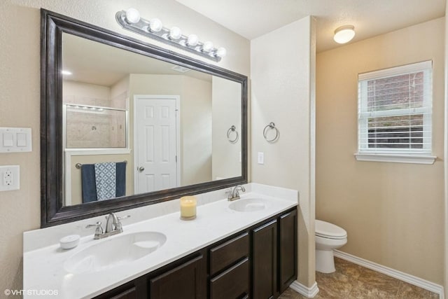 full bathroom with double vanity, toilet, baseboards, and a sink