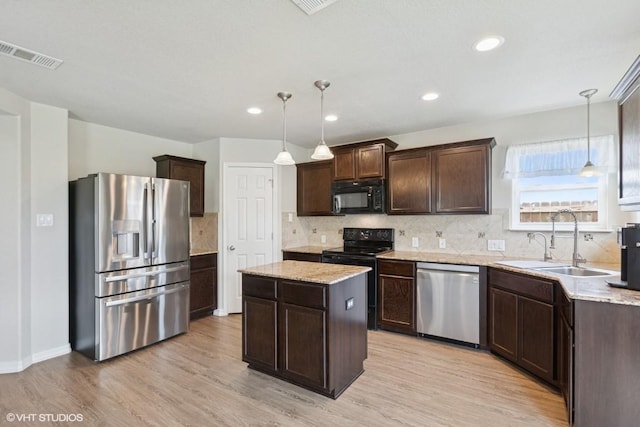 kitchen featuring a kitchen island, visible vents, dark brown cabinets, a sink, and black appliances