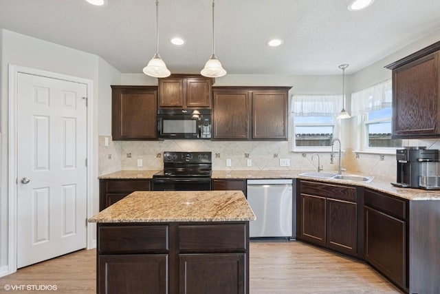 kitchen featuring a sink, black appliances, light wood-style flooring, and dark brown cabinets