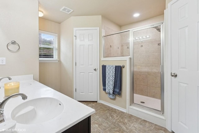 bathroom with visible vents, a sink, and a stall shower