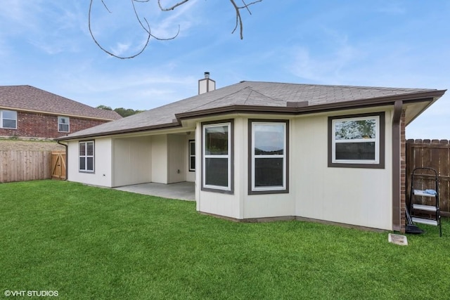 back of property featuring a fenced backyard, a patio, a chimney, and a yard