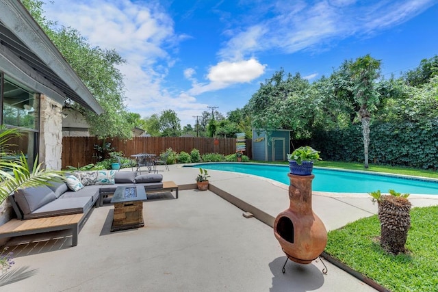 view of pool featuring a storage unit, outdoor lounge area, a fenced in pool, a fenced backyard, and a patio area