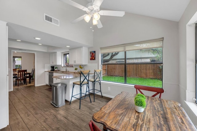 kitchen featuring plenty of natural light, white cabinets, visible vents, and dishwasher