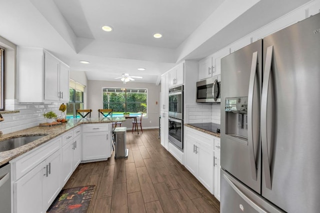 kitchen featuring dark wood-type flooring, a sink, white cabinetry, and appliances with stainless steel finishes