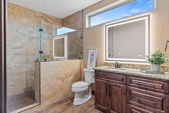 full bathroom featuring a textured wall, walk in shower, and wood finished floors