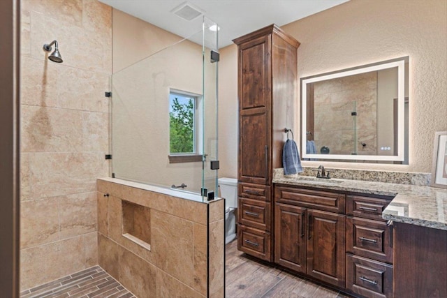 bathroom with vanity, a stall shower, and wood finished floors
