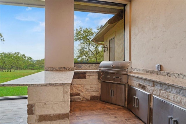 view of patio / terrace featuring an outdoor kitchen and a grill