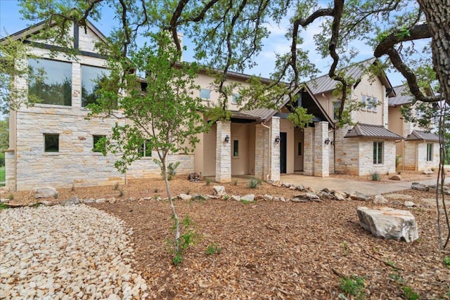 view of front of home with metal roof, stone siding, and a standing seam roof