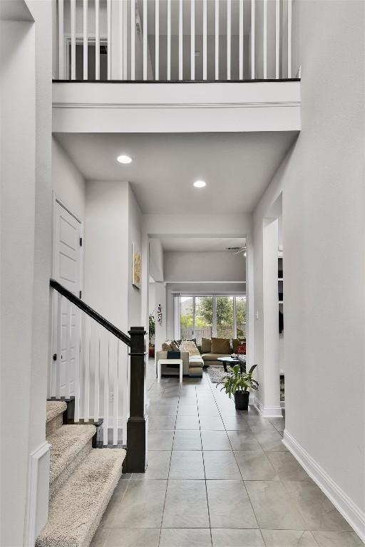 foyer with stairway, baseboards, tile patterned flooring, and recessed lighting