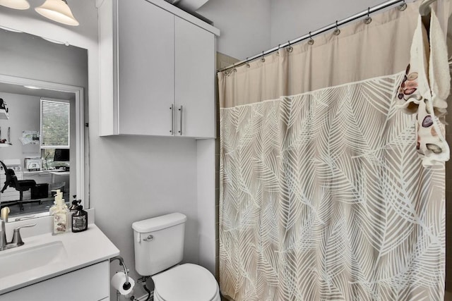 bathroom featuring toilet, curtained shower, and vanity