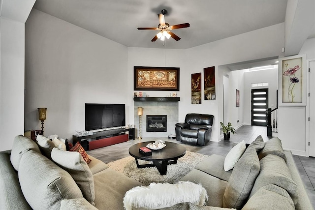 living area featuring ceiling fan and a fireplace
