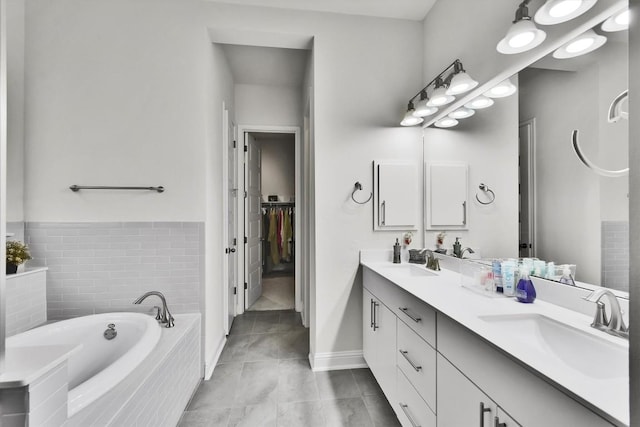 full bath featuring a garden tub, a sink, tile patterned floors, and double vanity
