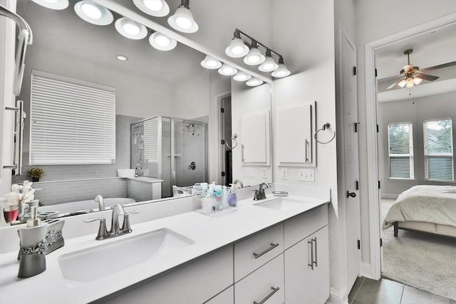 ensuite bathroom featuring tile patterned flooring, a sink, a ceiling fan, and a stall shower