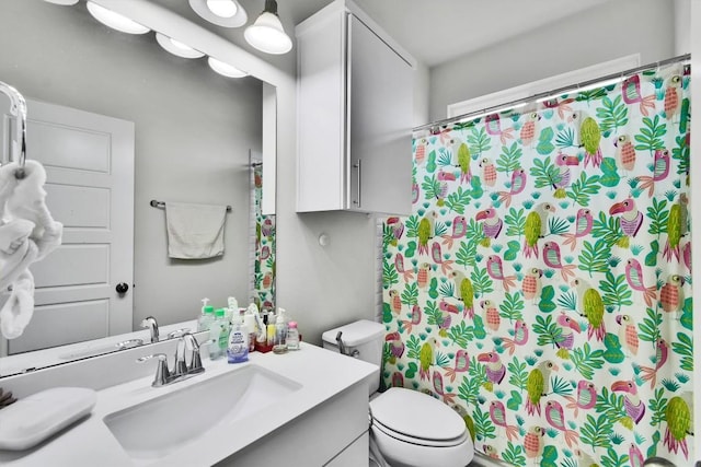 bathroom with toilet, a shower with shower curtain, and vanity