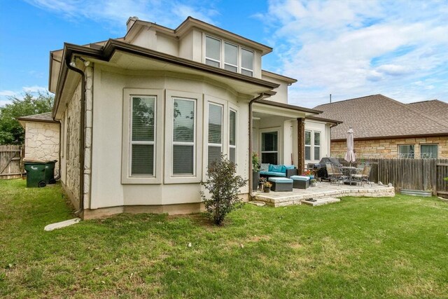 rear view of property with a fenced backyard, a patio, a lawn, and outdoor lounge area