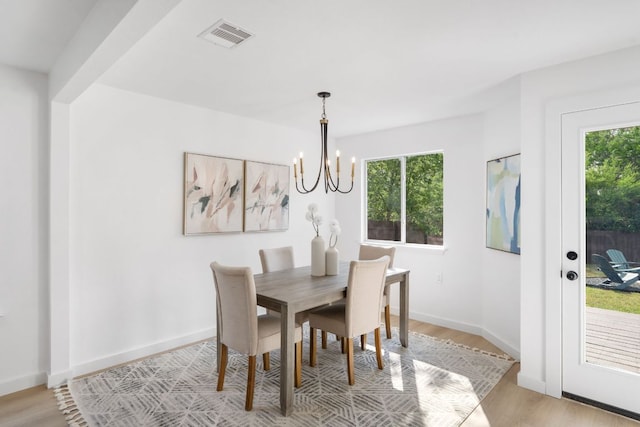815 Sheraton Ave, Austin, TX 78745 - dining area featuring a chandelier, plenty of natural light, light wood-style flooring, and baseboards
