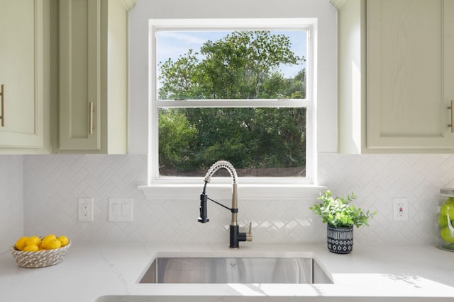 815 Sheraton Ave, Austin, TX 78745 - kitchen with a sink, decorative backsplash, light stone countertops, and cream cabinetry