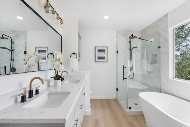 815 Sheraton Ave, Austin, TX 78745 - full bath featuring a stall shower, recessed lighting, wood finished floors, a freestanding bath, and double vanity