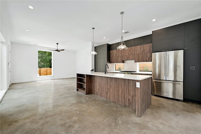 kitchen with high end refrigerator, a sink, concrete flooring, and modern cabinets