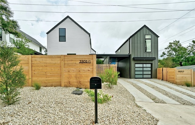 view of front facade featuring fence, board and batten siding, and driveway