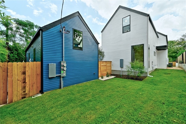 rear view of property with a yard and fence