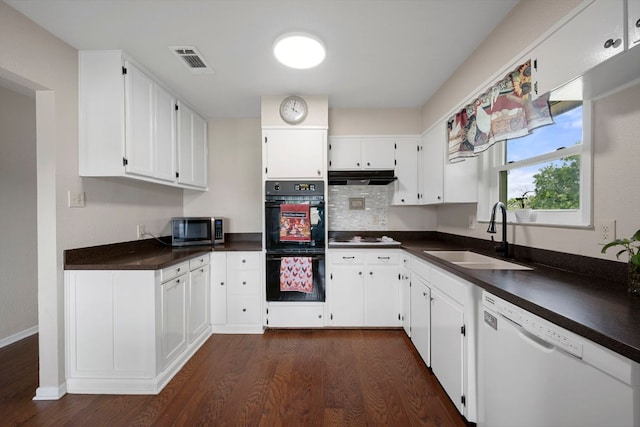 kitchen with visible vents, dark wood finished floors, a sink, under cabinet range hood, and white appliances