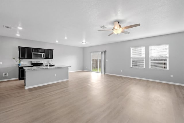 509 Peony Ct, Jarrell, TX 76537 - unfurnished living room featuring visible vents, light wood-style flooring, ceiling fan, and baseboards