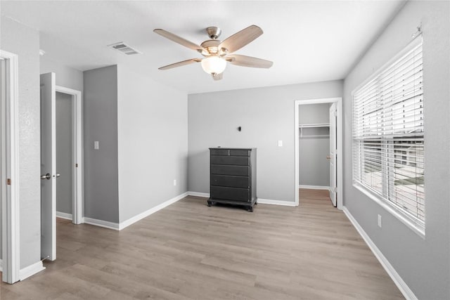 509 Peony Ct, Jarrell, TX 76537 - unfurnished bedroom with ceiling fan, light wood-style flooring, baseboards, a spacious closet, and visible vents